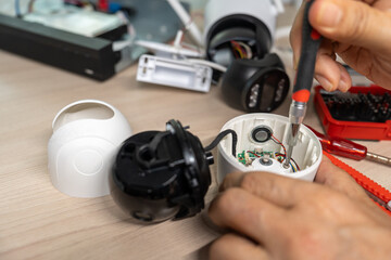 Close-up hand of man using screwdriver to repairing a wireless CCTV camera.