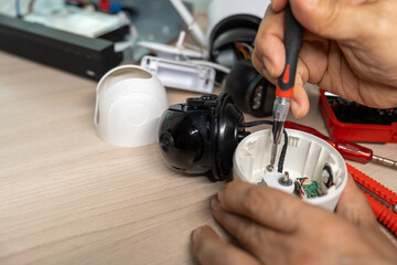 Close-up hand of man using screwdriver to repairing a wireless CCTV camera.