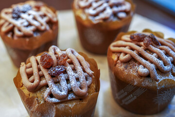 Appetizing sweet cupcakes with cream and dried fruit in a store window. Close-up. Selective focus.