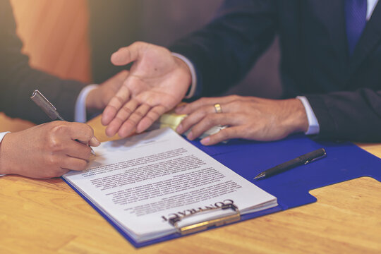 Businessman puts signature on contract at business meeting after negotiations with business partners. Selected focus