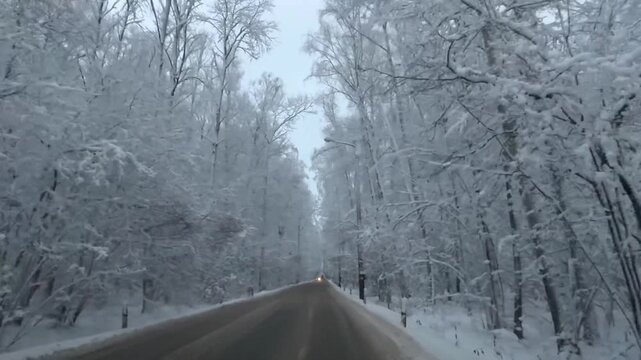 A snow-covered road in Odintsovo, Russia. A stunning landscape of cars on a winter road. The beauty of the scenery is breathtaking