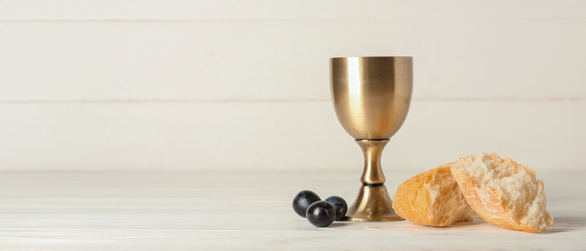 Cup of wine with bread on white wooden background