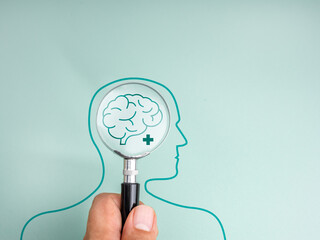 Concept image of brain health check and mindset awareness. A magnifying glass focuses on a brain inside a human head outline, symbolizing mental health, diagnosis, and awareness of brain diseases.