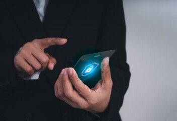 Businessman using futuristic transparent smartphone with data security icon. Concept of cybersecurity, digital protection, secure communication, and innovation in mobile technology and business.
