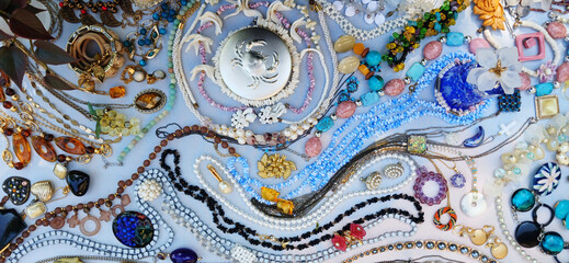 Fototapeta premium Assorted vintage jewelry arranged in a flowing flat lay pattern, creating a decorative background