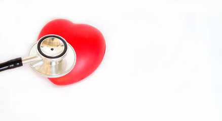 Healthcare concept showing stethoscope and red heart, simple white backdrop.