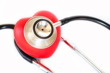 Minimal healthcare image of stethoscope and red heart, clean white background.
