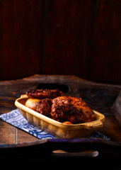 Fried chicken wings with potatoes on a rustic background. Soft focus.