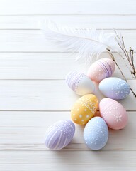 Decorative Easter eggs in pastel colors arranged on a rustic wooden surface, accompanied by a white feather and some delicate twigs.