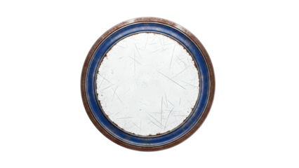 Close-up of a scratched, circular tin lid with blue and rust edges