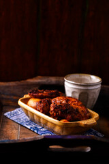 Fried chicken wings with potatoes on a rustic background. Soft focus.