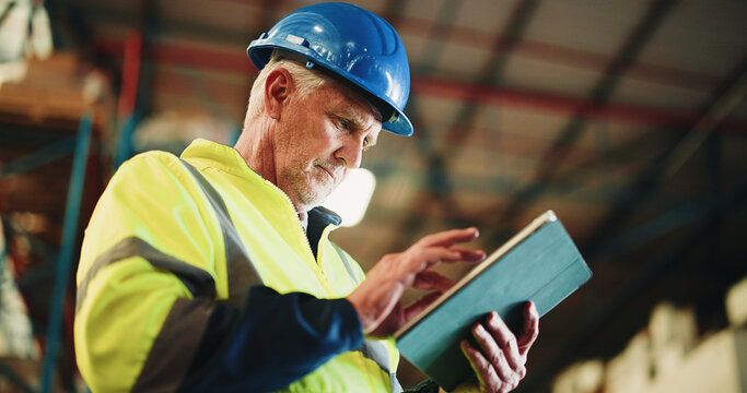 Tablet, ecommerce and mature man in warehouse with email for cargo information with supply chain. Technology, industry and male logistics manager with online inventory for stock delivery from below.