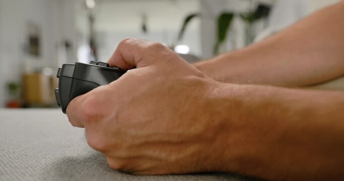 Close-up of male hands holding black video game controller 