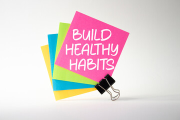 Healthy habits symbol. Concept word Build Healthy habits on pink sticky note. Beautiful white background. Healthy lifestyle and Healthy habits concept. Copy space