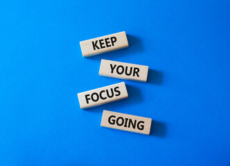 Focus symbol. Concept words Keep Your Focus Going on wooden blocks. Beautiful bright blue background. Business and Keep Your Focus Going concept. Copy space.