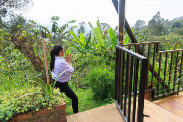 Woman drinking coffee while enjoying mountain view at coffee plantation