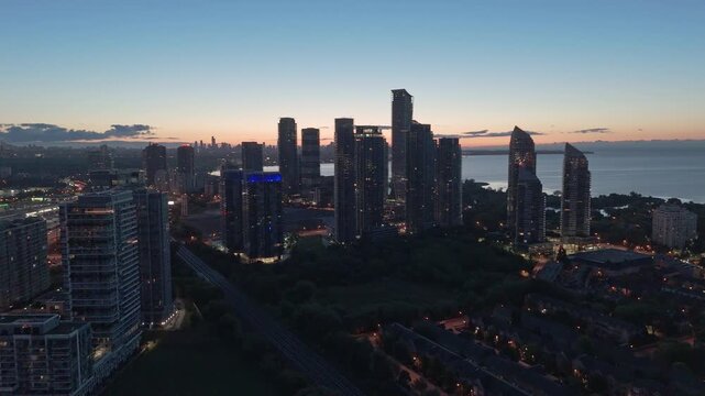 Sunrise aerial over Parklawn condominium business buildings in Etobicoke with Toronto skyline and Lake Ontario waterfront in the background.