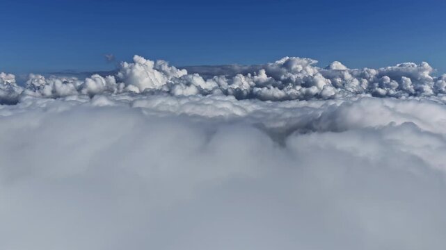 Aerial view of fluffy clouds with blue sky, serene and peaceful atmosphere