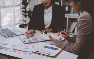 Businesswomen analyzing financial data calculating project expenses
