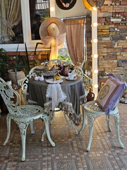 A country veranda with iron garden furniture and a set table