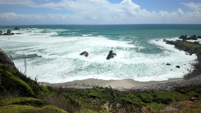 Powerful surf in rocky bay viewed from coastal bluff