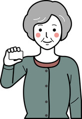 正面向き。カードを持つカーディガンを着た高齢女性。