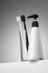 Toothbrushes and pump bottle for daily dental hygiene. Hero view shot.