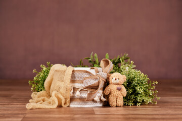 Backdrop with empty box with boho style lace, teddy bear and brown background
