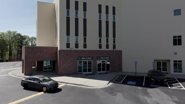 Car entering with welcome sign at door in focus