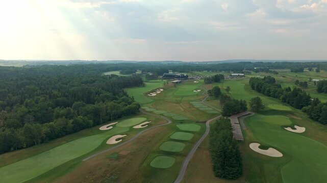 Smooth drone approach over TPC Toronto at Osprey Valley, showing practice greens, bunkers, and fairways in Alton, Caledon, Ontario, Canada.
