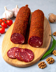 Dry Cured Salami with Red Pepper Coating and Garlic on Cutting Board
