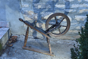 Rustic vintage wooden spinning wheel for spinning yarn, a decorative and historic farmhouse collectible