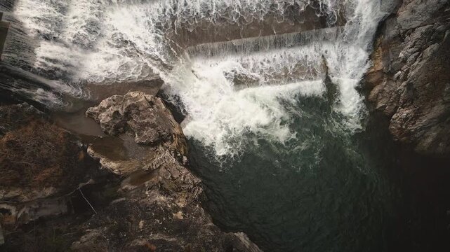 Drone rises up from Lechfall's roaring multi-step cascade in Fussen, showcasing churning turquoise waters amid dramatic rocky gorge and Lech River. Powerful Bavarian nature.