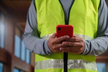 A professional construction engineer or site supervisor stands confidently in a modern wooden...