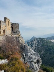 St. Hilarion Castle surrounded by the Kyrenia Mountains in soft morning mist, creating an atmospheric view of the medieval fortress rising above the landscape of northern Cyprus