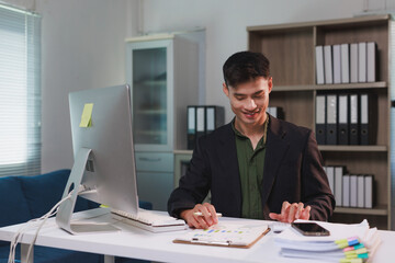 Young businessman analyzing financial data at office desk