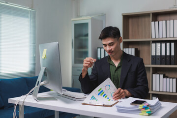 Young businessman analyzing financial reports in office