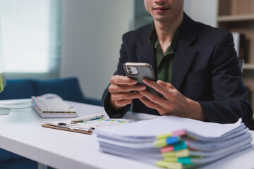 Professional man working at desk using smartphone