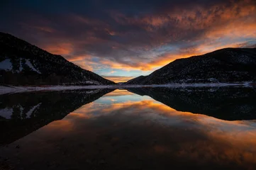 Poster Reflectie Intensely colorful sunset cloudscape over Grass Valley Reservoir in Harvey Gap State Park, Colorado reflected in reservoir's calm water.  © Francisco