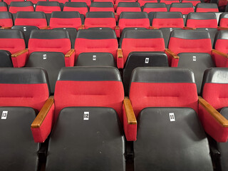 Fototapeta premium Empty red and black theater seats in an auditorium.