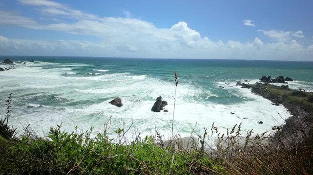 Wild ocean surf and sea stacks from grassy cliff edge