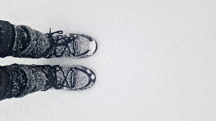 Winter, wintertime concept. Snow-covered winter boots standing in fresh white snow. Space for text.