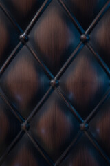 Fototapeta premium Luxury dark brown quilted leather texture with diamond pattern and buttons. Classic tufted upholstery background for furniture design