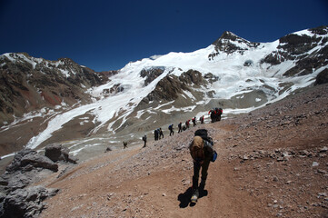 The movement of climbers in rows in extreme conditions on snowy, steep mountains