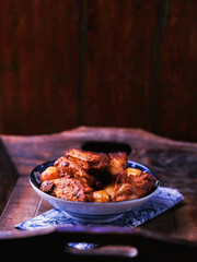 Fried chicken wings with potatoes on a rustic background. Soft focus.
