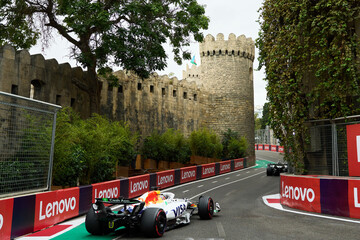 Obraz premium BAKU, AZERBAIJAN - SEPTEMBER 20, 2025: A Formula 1 racing car from the Visa Cash App RB team drives through the iconic narrow Old City (Icherisheher) section near the walls