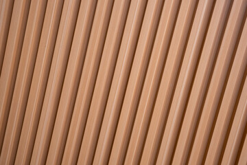 Diagonal pattern of modern wooden slats or vertical timber cladding. Minimalist brown background for architectural and interior design