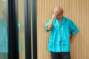 Elderly man with pain and illness standing on black wall background	