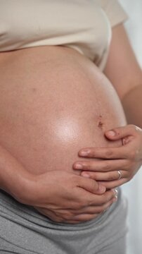 Happy pregnant woman or mother touching baby in belly with love at home. Health care, Prenatal preparation, Maternity, Pregnancy, and motherhood concept