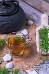 Equisetum arvense herbal tea with iron teapot and wooden scoop on rustic background